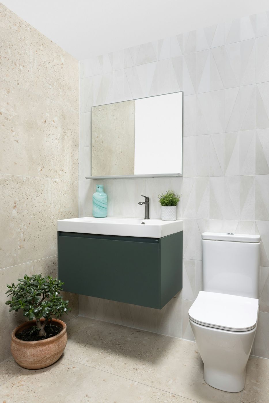 A wall-faced toilet in a styled bathroom