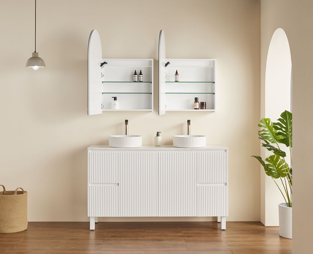 Arched LED shaving cabinets open above a fluted vanity